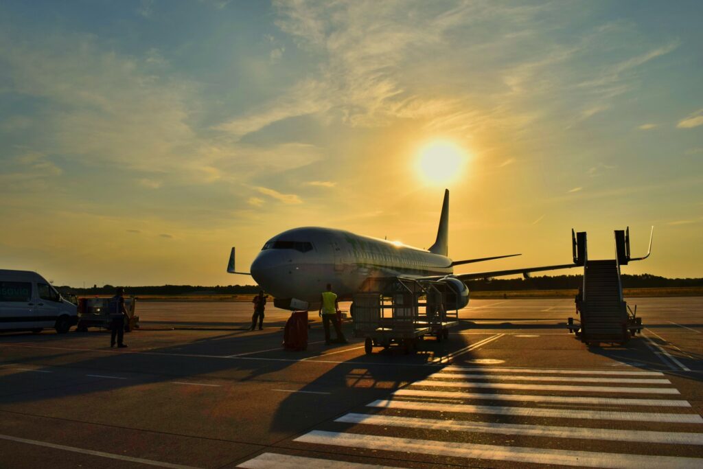 plane on runway in front of crossing against sunset