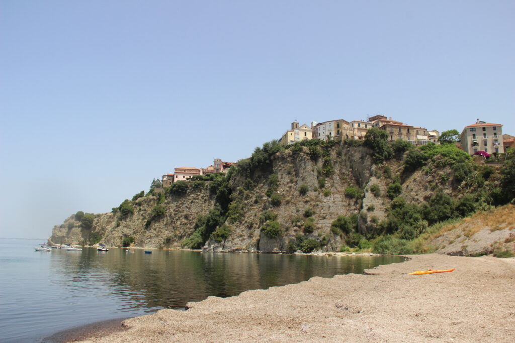 View from beach up to Agropoli town on top of cliff with sea beneath