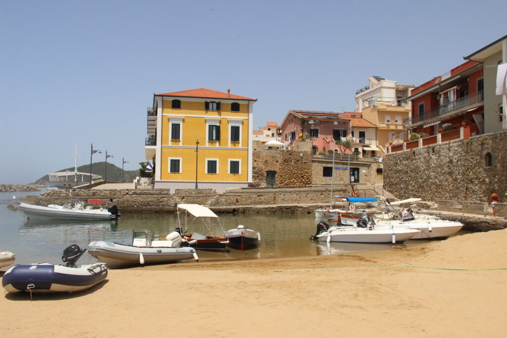 beach with sea and boats and property in distance 